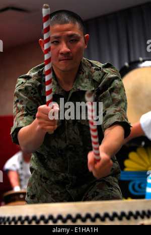Soldiers of the Japan Self Defense Force give a thrilling Taiko drum performance for a large assembly of American and Japanese Stock Photo