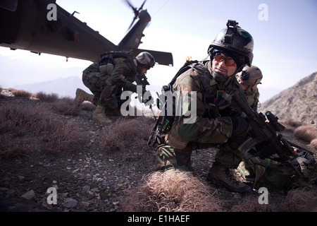 An Afghan National Army commando dismounts a UH-60 Black Hawk helicopter during a mission in Chawkai district, Kunar province, Stock Photo