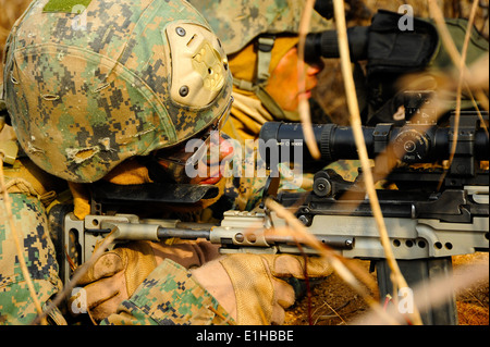 U.S. Marine Corps Lance Cpl. Matthew Guerrero, background, assigned to Fleet Antiterrorism Security Team (FAST) Pacific, uses a Stock Photo