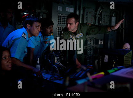 U.S. Navy Tactical Action Officer Lt. Dan Mitzner, right, discusses combat direction center operations with Indian Navy Liaison Stock Photo