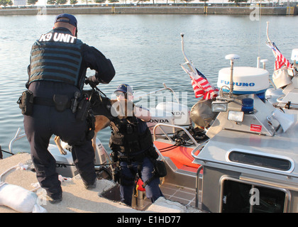 U.S. Coast Guard Petty Officer 2nd Class Nicholas Heinen, a maritime enforcement specialist and canine handler stationed at Mar Stock Photo