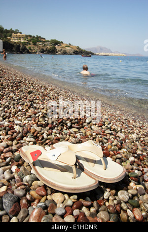 pair of flip flops on pebble beach, Rhodes Islands, Vliha Bay, Greece Stock Photo