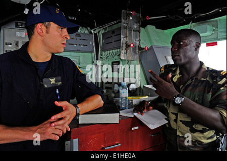 U.S. Coast Guard Lt. Randy Sinclair, left, assigned to a maritime security response team, discusses boarding strategies with Se Stock Photo