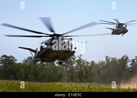 Two U.S. Marine Corps CH-53E Super Stallion helicopters attached to Marine Heavy Helicopter Squadron (HMH) 366 land to recover Stock Photo