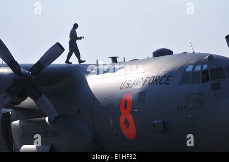 U.S. Air Force Master Sgt. Rodney Hall walks the wing of a C-130 Hercules aircraft equipped with the Modular Airborne Fire Figh Stock Photo