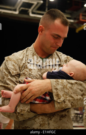 U.S. Marine Corps Cpl. Jacob L. Nichols, with Marine Heavy Helicopter Squadron (HMH) 366, holds his 2-month-old son for the fir Stock Photo