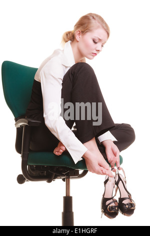 Work stoppage. Tired businesswoman taking shoes off Stock Photo