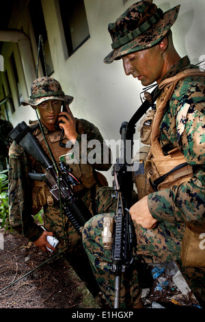 U.S. Marine Corps Lance Cpl. Clayton Climer, left, a rifleman, calls in a medical evacuation request as Staff Sgt. Jeremy Ludwi Stock Photo