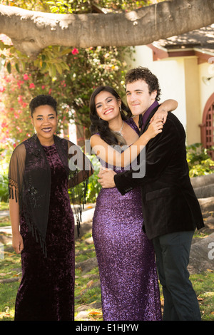 Black/Irish woman, Greek/Lao woman and White/Chilean man posing outdoors in formal attire Stock Photo