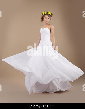 Beautiful Fiancee with Vernal Wreath of Flowers in Flying Wedding Dress Stock Photo