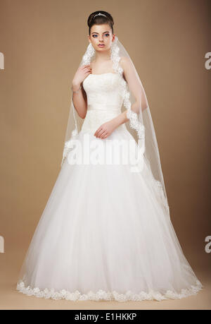 Portrait of a beautiful bride in white wedding dress smiling and ...