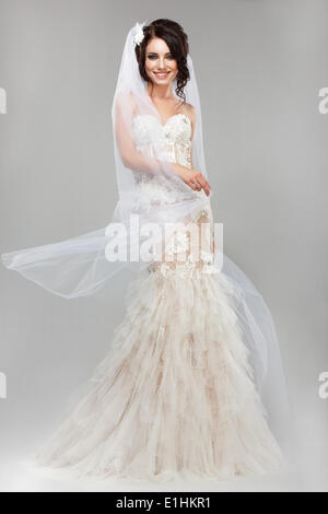 Expression. Positive Emotions. Gorgeous Smiling Bride in Windy Wedding Dress Stock Photo