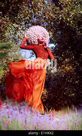 Creativity. Ultramodern Woman Blond in Artificial Huge Futuristic Wig Outside Stock Photo