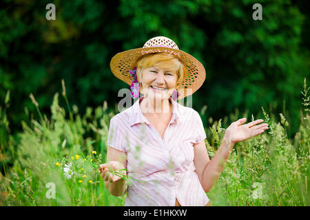 Joy. Friendly Happy Mature Woman in Straw Hut with Stretched Arms Stock Photo