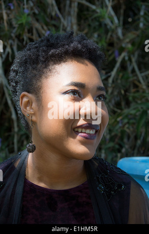 Outdoor portrait of a Black young woman in a purple velvet gown Stock Photo