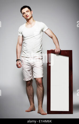 Full Length of Young Barefoot Man in White Shorts with Plackard Stock Photo