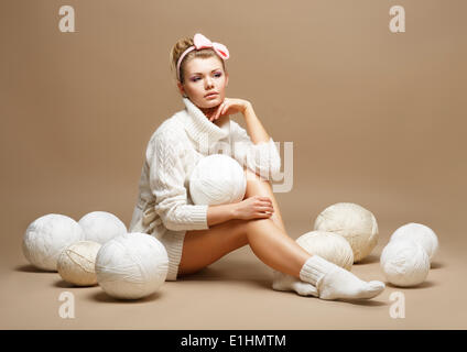 Embroidery. Woman in sitting White Cotton Knitwear with Heap Balls of Yarn Stock Photo