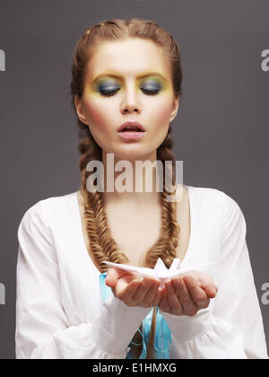 Aspiration. Caucasian Woman in White Dress releasing Origami Pigeon. Kindness Stock Photo