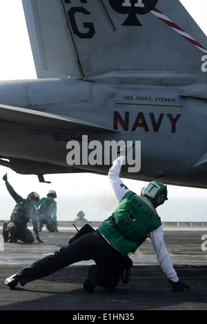 U.S. Sailors signal for the launch of an F/A-18F Super Hornet aircraft with Strike Fighter Squadron (VFA) 41 on the flight deck Stock Photo