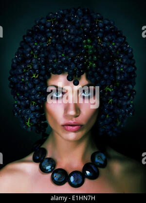 Portrait of Autumn Woman with Grapes on her Head. Trendy Hairstyle Stock Photo