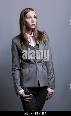 Trendy fashionable model girl posing in gray costume posing. Studio shot Stock Photo