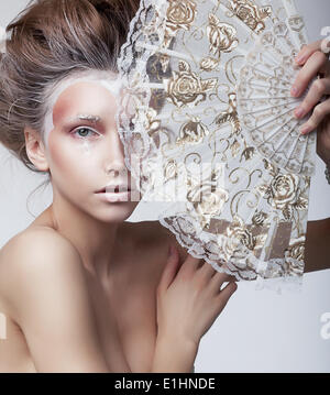 Renaissance. Vintage. Genuine Delightful Woman holding Old-Fashioned Classic Fan Stock Photo