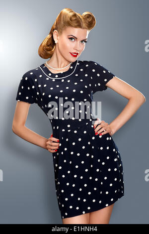Pin-up girl in retro vintage old-fashioned dress in romantic pose Stock Photo