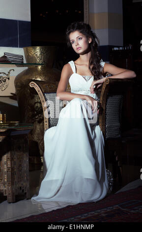 Wedding Style. Aristocratic Bride sitting in White Dress. Restaurant Interior Stock Photo