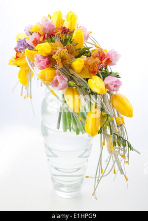 Floristry - colorful flower bouquet arrangement centerpiece in transparent vase isolated on white background Stock Photo