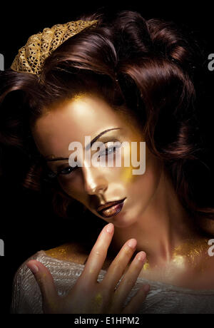 Paint. Fantasy. Glamor. Creative gold make-up, beauty woman face and fashion style Stock Photo