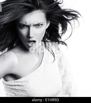 Young woman screaming on white background - black and white photo
