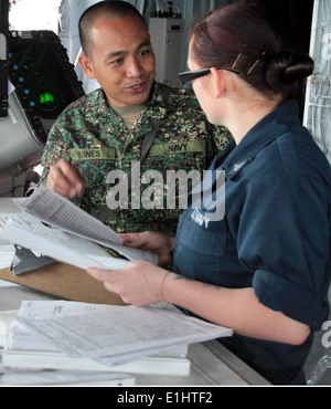 Philippine navy Lt. Salvador Quines, left, a liaison officer, speaks with U.S. Navy Quartermaster 3rd Class Chrystal Evans at t Stock Photo