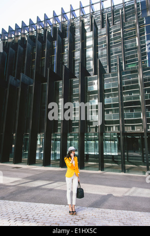 Spain,Catalunya, Barcelona, young modern woman with yellow jacket on the move Stock Photo