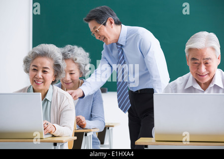 Senior adults having computer class at school Stock Photo