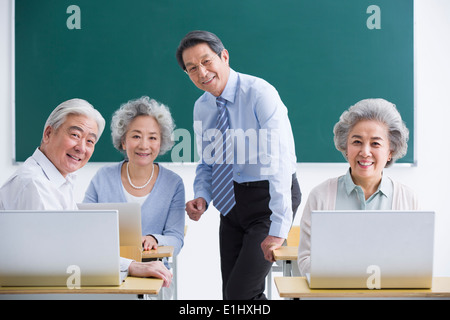 Senior adults having computer class at school Stock Photo