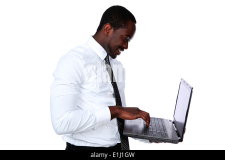 Happy african man standing and using laptop over white background Stock Photo