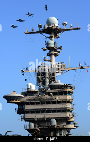 U.S. Navy F/A-18 Hornet aircraft break formation above the aircraft carrier USS John C. Stennis (CVN 74), March 22, 2013, while Stock Photo