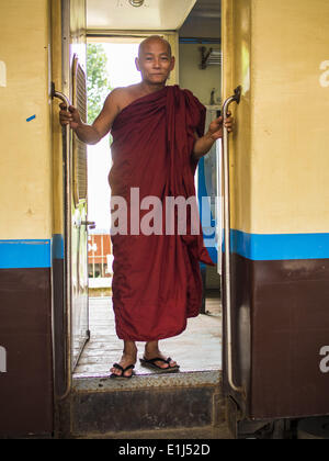 June 5, 2014 - Yangon, Yangon Region, Myanmar - A Buddhist monk stands in the doorway of a rail car on the Yangon Circular Train. The Yangon Circular Train is a commuter train that circles Yangon, Myanmar (Rangoon, Burma). The train is 45 kilometers long, makes 38 stops and takes about three hours to make a loop of the city. (Credit Image: © Jack Kurtz/ZUMAPRESS.com) Stock Photo