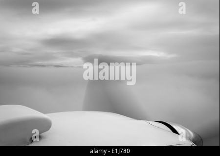 Aerial view out the cockpit of a Beechcraft Baron B58 in flight on a cloudy day between cloud layers - black and white photo Stock Photo