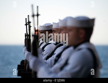 U.S. Sailors with the rifle detail aboard the aircraft carrier USS Carl Vinson (CVN 70) stand at attention during a burial at s Stock Photo