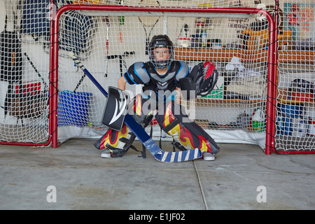 Boy in hockey goal wearing protective sportswear Stock Photo