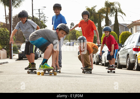 Boys skateboarding on road Stock Photo