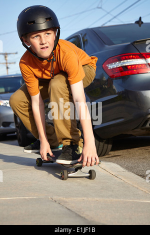 Boy skateboarding on pavement Stock Photo