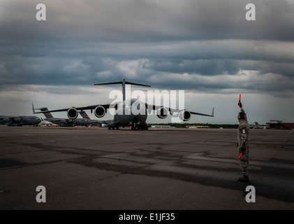 U.S. Air Force Senior Airman Eric Halchak, a crew chief with the 437th Aircraft Maintenance Squadron, guides a new C-17 Globema Stock Photo