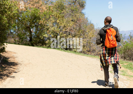 Young man with backpack strolling in park Stock Photo