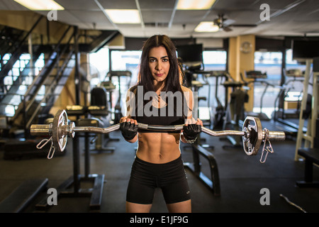 Portrait of mid adult woman weightlifting in gym Stock Photo