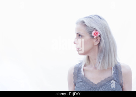 Portrait of mature woman with flower in hair Stock Photo