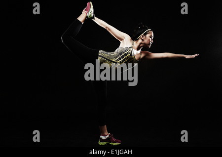 Young woman standing on one leg Stock Photo