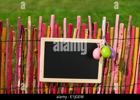 Blackboard on a colorful garden fence Stock Photo