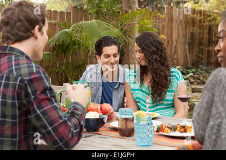 Friends sitting around table sharing barbecue food Stock Photo